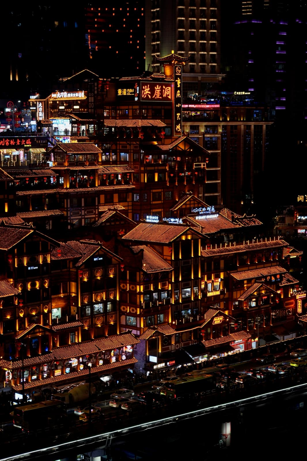 Hongyadong illuminated at night in Chongqing with layered architecture and surrounding high-rises